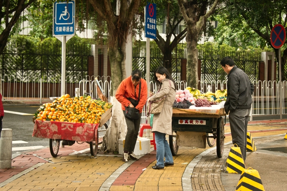 Sporadically street vendors are occupying spaces they think most strategic to do their business. This bicycle path is completely blocked by fruit vendors making their living.