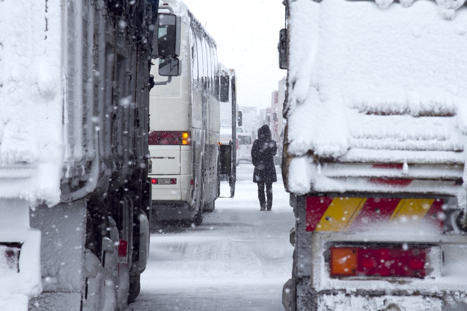 A snow storm caused an accident that created a long traffic jam on the highway.