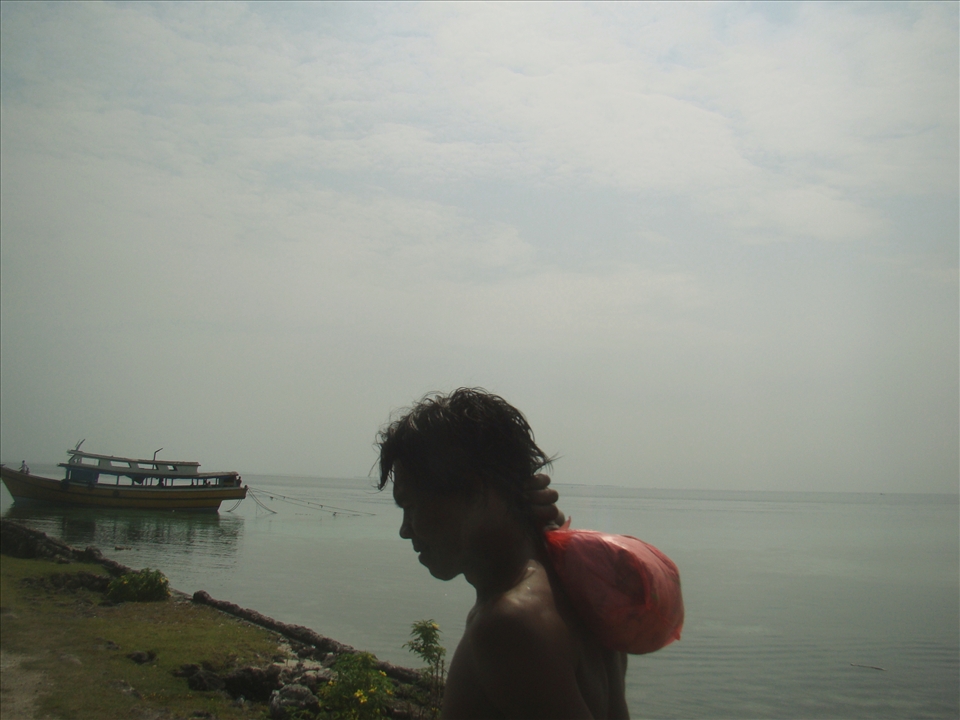A man trudges on the shores of Tawi-Tawi under the beating sun. 