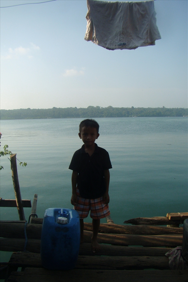 A Badjao kid poses against the sea view from the houses-on-stilts village.