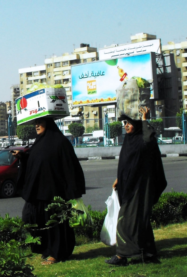 Two strong women in their abayas carrying big crates with no difficulty, in the middle of a busy street in Cairo.