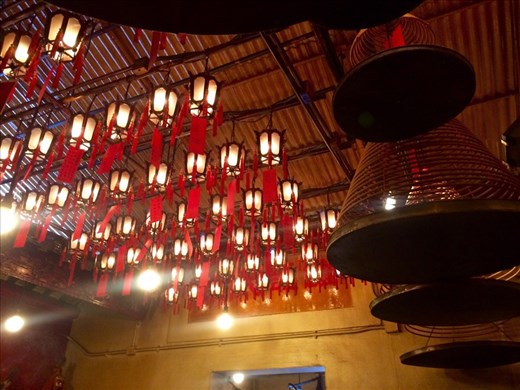 The lanterns and incense at the temple.  The triangular spirals are burning incense with a tin to catch the ashes hanging below them.