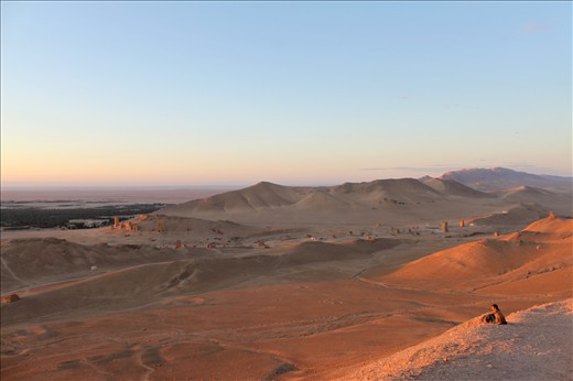 Golden sunlight shines over the Palmyra desert, as many tourists sit up by the ancient Citadel to watch the sunrise.