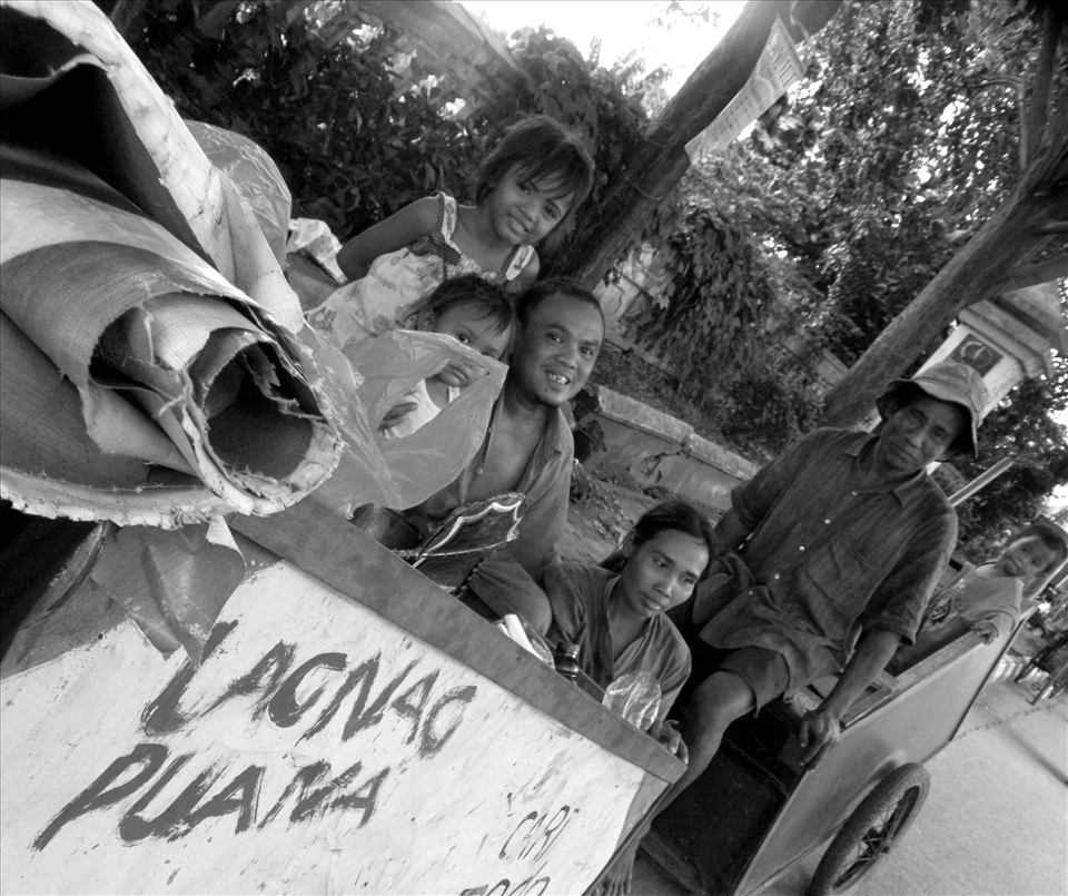 these scavengers families consisting of grandparents, father, mother, brother and sister are resting after working all day looking for garbage and collected in wheelie bins. Nevertheless, they still look happy smiles
