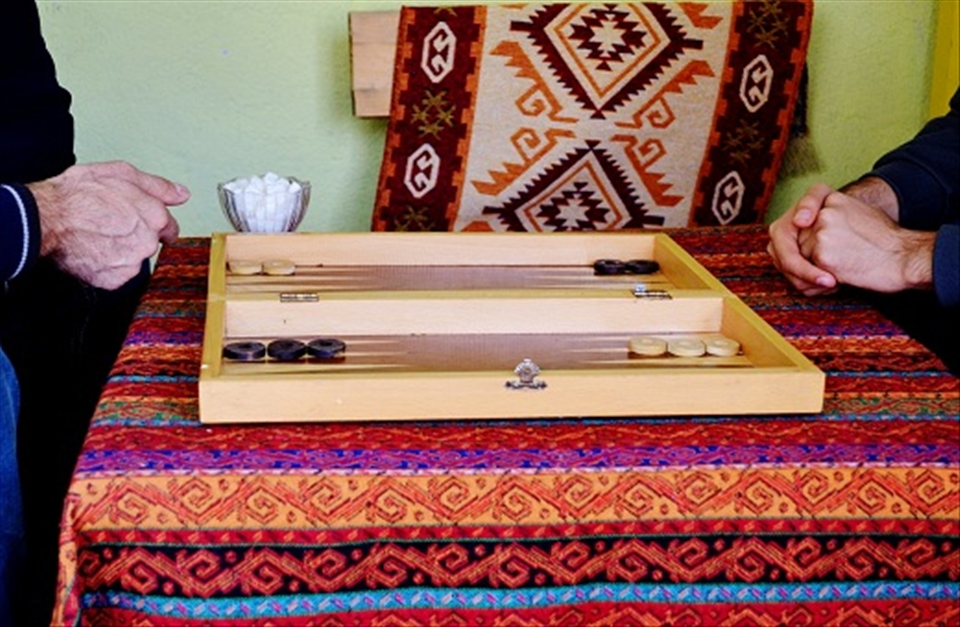 Title: Tavla.
The Backgammon (tavla) is the most popular table game in Turkey. There are special places usually attended only by men, where they play and chat accompanied by Turkish traditional tea for couple of hours. This picture was taken in a small village called Tortum, 60 km from Erzurum, in the Eastern Anatolia of Turkey, in November of 2012. Although is not high season, it is always possible to find a board available somewhere. Behind the board, sugar blocks are waiting for the tea.
