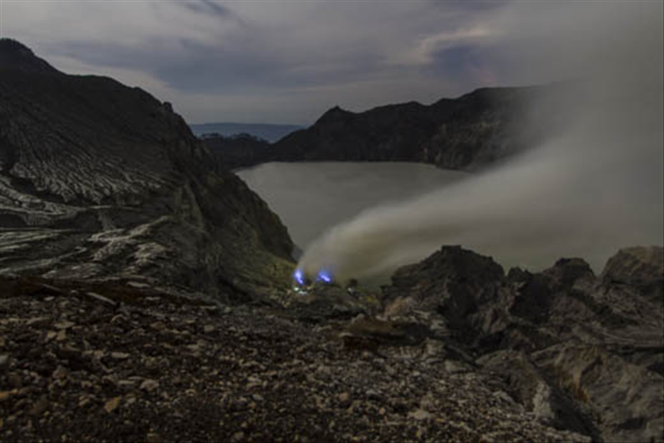 the blue flames of molten sulfur and flashlights of the miners of Ijen