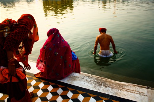 A visitor surrenders himself to a dip in the pool of holy water.