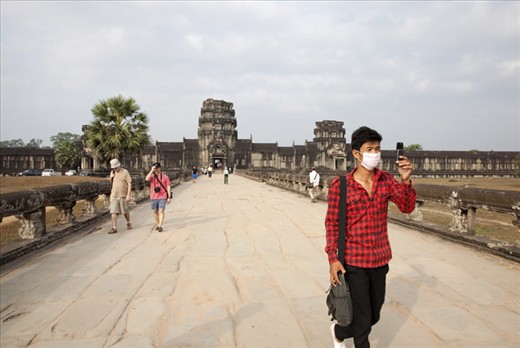 A young man captures the vast façade of the temple ahead with a cell-phone camera. This complex has witnessed the evolution of human image making since the story of its construction was etched into its walls nearly 1000 years ago. 