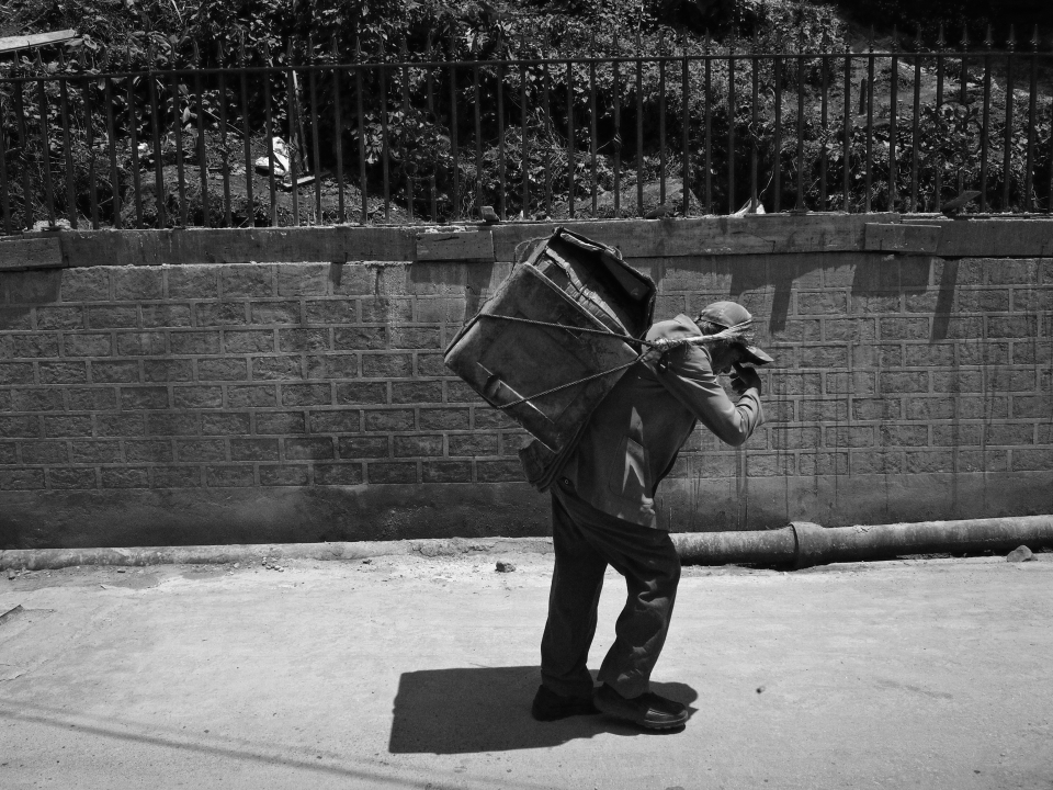 Pressure from tourism is such that the locals are feeling the burden of it. Seen here in the image is a local street vendor carrying the load heading towards Chowrasta to put up his makeshift shop.