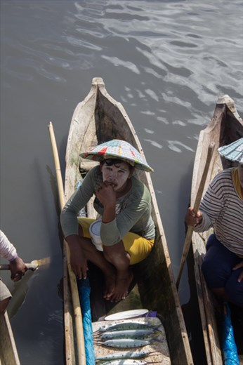 A Bajo fisherwoman visits the fish market to sell her catch and buy fresh water.