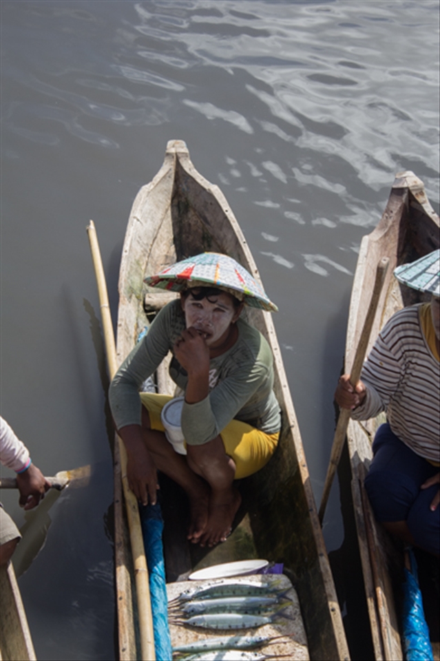 A Bajo fisherwoman visits the fish market to sell her catch and buy fresh water.