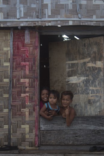 Children on Sampella wave and smile to get their photos taken by visitors.