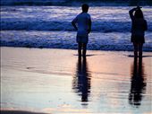 A young couple stand in the wash of the surf watching the sunset.: by ndunning, Views[293]