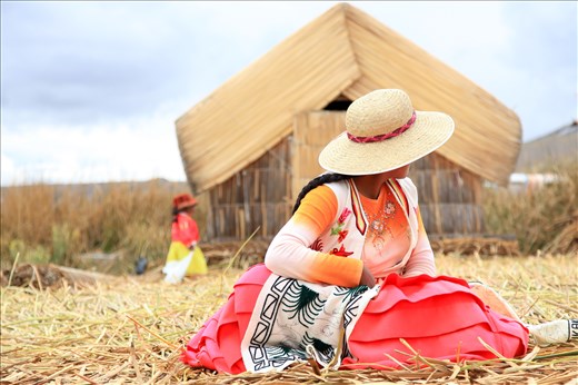 Native woman on Santa Maria of the floating islands of Uros, Lake Titicaca. Women here design craft items to sell to tourists. This particular woman was weaving an interpretation of Pachamama or 