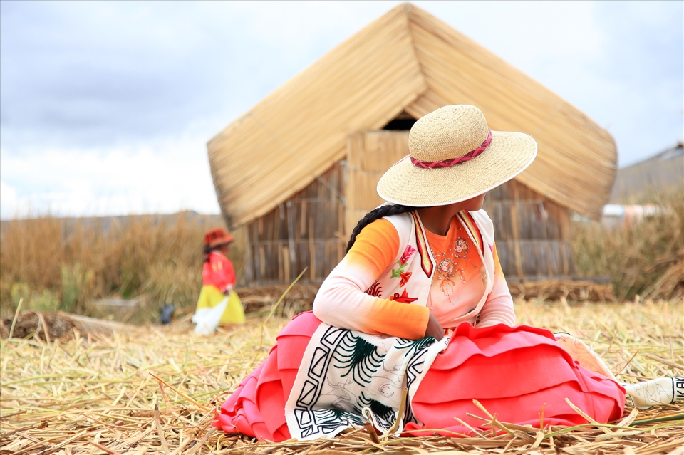 Native woman on Santa Maria of the floating islands of Uros, Lake Titicaca. Women here design craft items to sell to tourists. This particular woman was weaving an interpretation of Pachamama or 