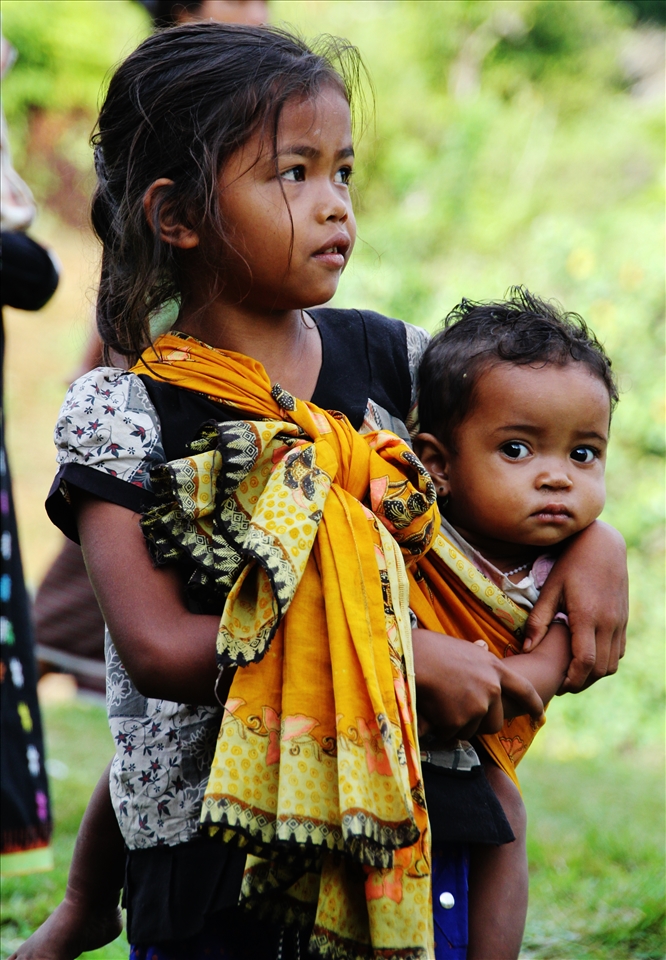 A young girl protecting her little sister by playing 