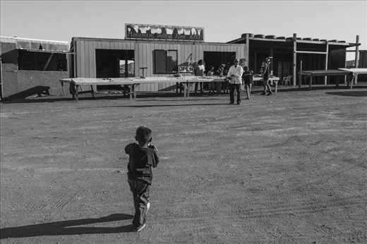 #3: Again, due to legal and historical reasons they have their own legislation and US laws don't apply to them, meaning certain rules that come as natural to a 'Western' tourist don't apply. 

The boy on the photo was out of school, playing with a toy gun, yet wearing jeans and t-shirt, suggesting that his family actually spent their money on 'American' things rather than investing into their store. 