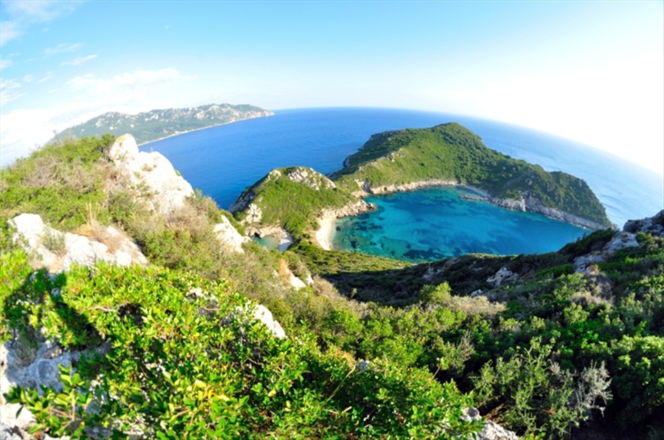 Corfu is a Greek island and for its natural treasures I think is a God’s blessed. 
Porto Timoni in the northwest part of Corfu reveals breathtaking view.
It is said that the smaller bay on the left of the photograph was created (or at least enlarged) by an exploding mine which drifted onto these rocks.
