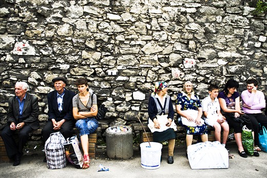 People sit at the bus station of Zhovkva. 