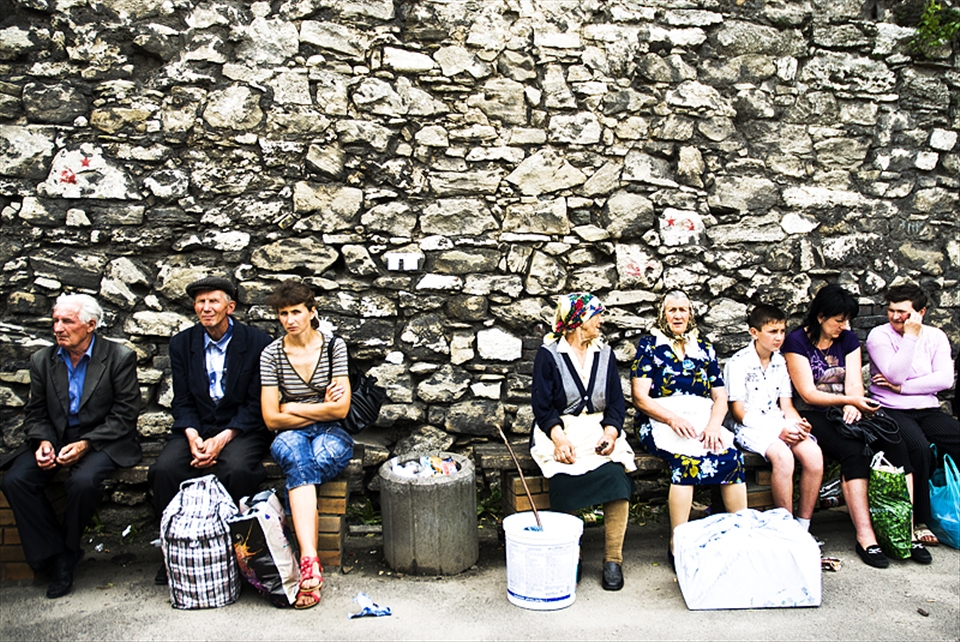 People sit at the bus station of Zhovkva. 