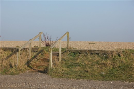 From the car park, this wooden structure leads the way, showing the hint of the beach beyond it.