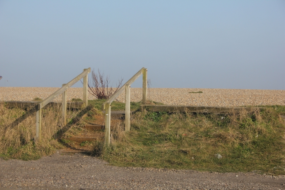 From the car park, this wooden structure leads the way, showing the hint of the beach beyond it.
