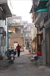 The laneways of the Old City in Ahmedabad hold many stories of both ancient and contemporary life. A 200 year old dwelling built up against a 400 year old building joined to 600 year old architecture provides a visual feast of texture and colour.  In contrast this family is amidst contemporary daily life oblivious to their everyday surroundings captivating my heart and how I will remember it forever and share it with the world through my lens.: by nicolecrouchdesigns, Views[1087]