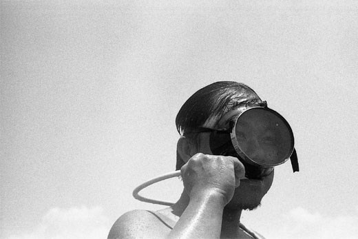 A diver clears his breathing tube.