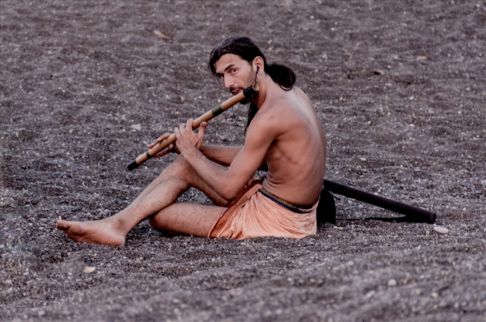 the solitary flute-man at sunset, spreading music to the entire volcanic beach.