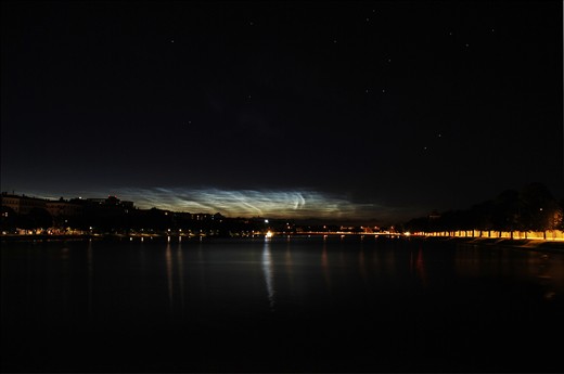 Even with only 2 hours of night in the summer, it is still possible to experience nightly phenomenons. Noctilucent clouds over Copenhagen reflect in the calm lakes.