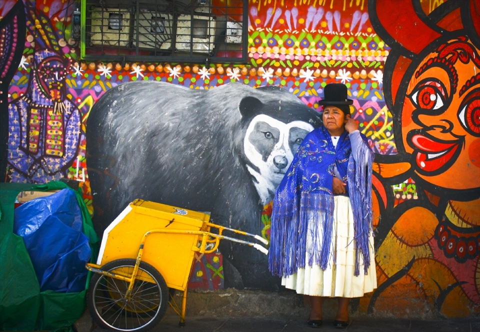 Sojourn :
In spite of having a difficult life, Bolivians make time for their families. She was waiting against this perfect background of a wall for a bus when I sneaked this picture. Later, it turned out we were both going to take the same bus for a long journey. After I put her at ease with my Spanish, she told me her name was Ava and she had taken a few days off to go to Sucre to take care of her widowed sister who had just suffered a heart attack. She was a very well-spoken and dignified woman.
NB: For continuation of my story, please take this as photo # 4. (I could not change the order of the photos)