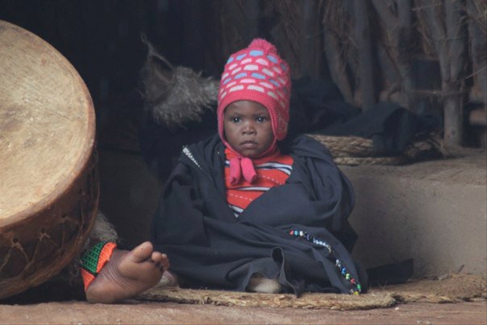 Durban South Africa, a kid sitting and watching his parents perform tribal dance