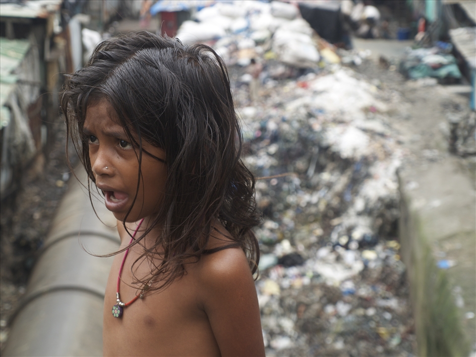 This child lives in a hut beside a mountain of putrid garbage and toxic water