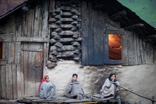 As dusk sets in, women & their family, sit outside waiting for their men to return from work. 