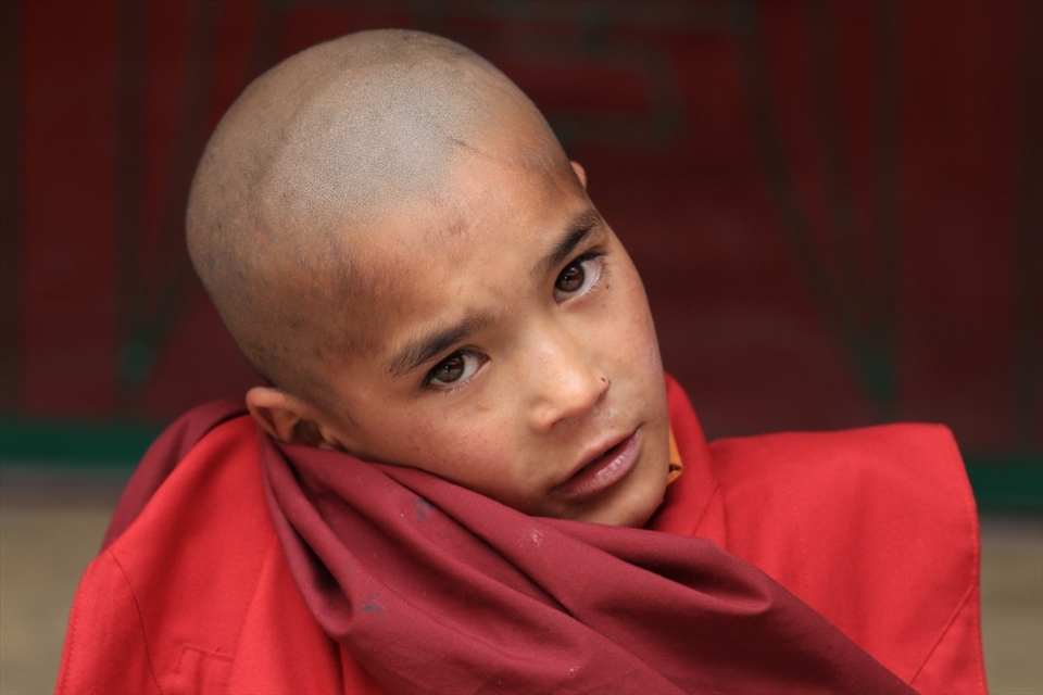 A little monk, stares into my lenses as I walk into one of the oldest monasteries of Ladakh - Lamayuru.
