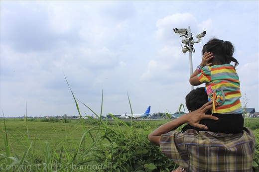 A young girl closed her ears because of the very loud sound of taking-off plane.

This park's located very close to the runway, less than 500m.
It's also featured with the CCTV controlled by the airport officials.
