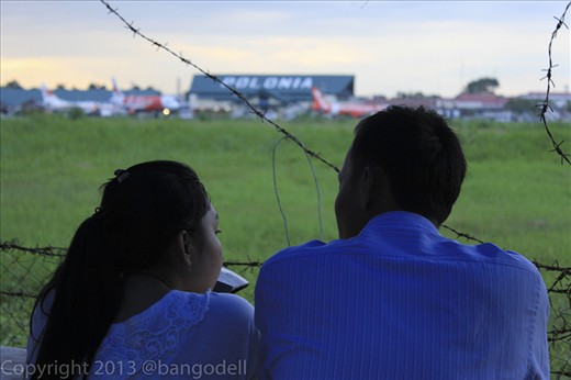 A couple is enjoying the view of runway.
People really enjoy this place because its uniqueness.

I also often visit this place just to have relax.