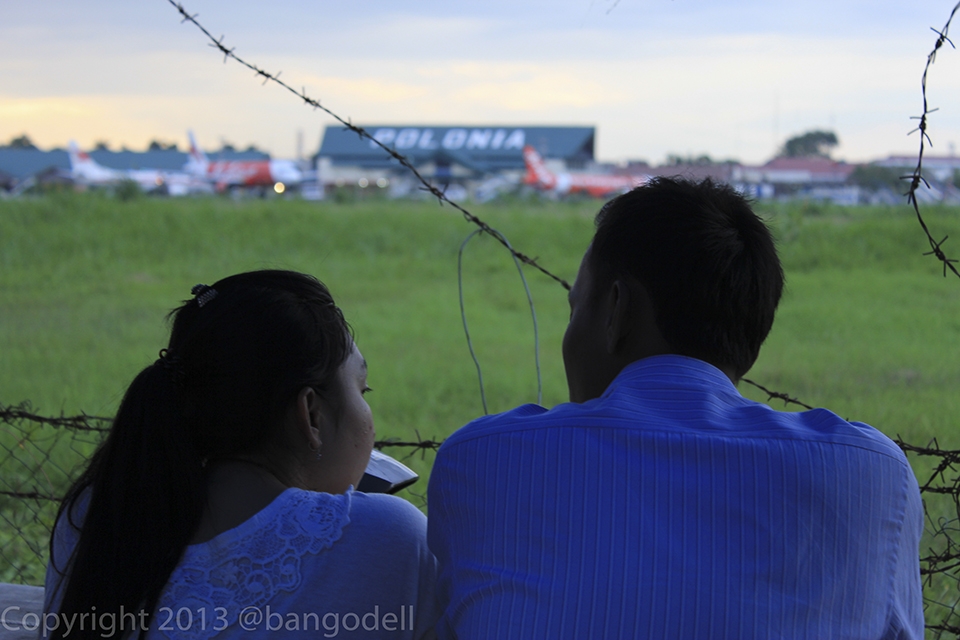 A couple is enjoying the view of runway.
People really enjoy this place because its uniqueness.

I also often visit this place just to have relax.