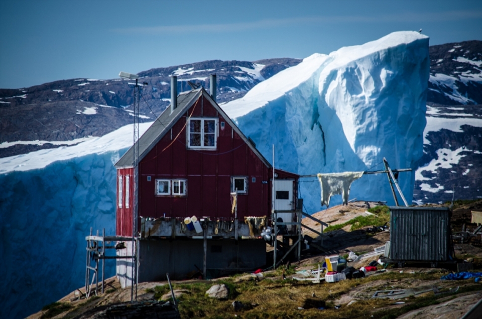 In Northern Greenland there is a village close to Upernavik which has gigantic icebergs close to it every year; the village is called Innaarsuit.
I went there not sol long ago with my dad when I heard about the iceberg and found a good spot to use the house as a background.
I really like the details here; the house is a very common hunter house nowadays, as you can see there is a polar bear skin hanging outside and there is bunches of equipments by the hunter who lives in the house. In addition there is a bird which is on the top of the iceberg on the right side which also caught my attention. I really love to mix up lots of different color sometimes, as you can see here. I