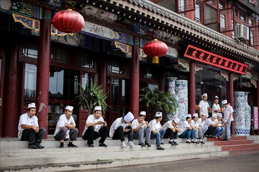 Chefs on their break sitting on the steps outside a restaurant. Like in any other country what the everyday people of China value and desire ultimately shapes the country around them. The governments ability to enable those people to live in a fulfilling way could determine the prosperity of the Country.  
