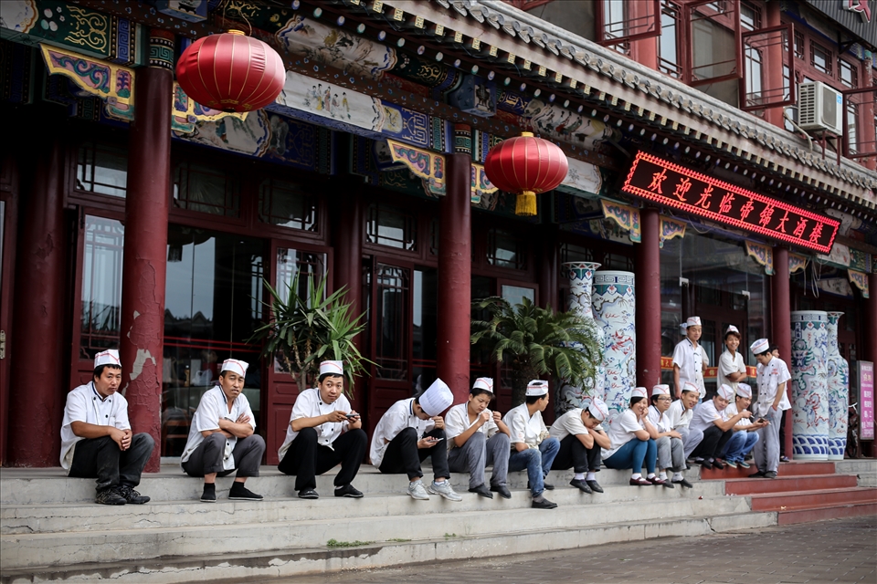 Chefs on their break sitting on the steps outside a restaurant. Like in any other country what the everyday people of China value and desire ultimately shapes the country around them. The governments ability to enable those people to live in a fulfilling way could determine the prosperity of the Country.  
