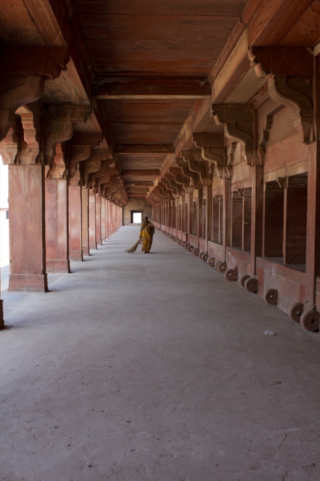 A woman sweeps a long hall of the Fatephur Sikri complex in Agra
