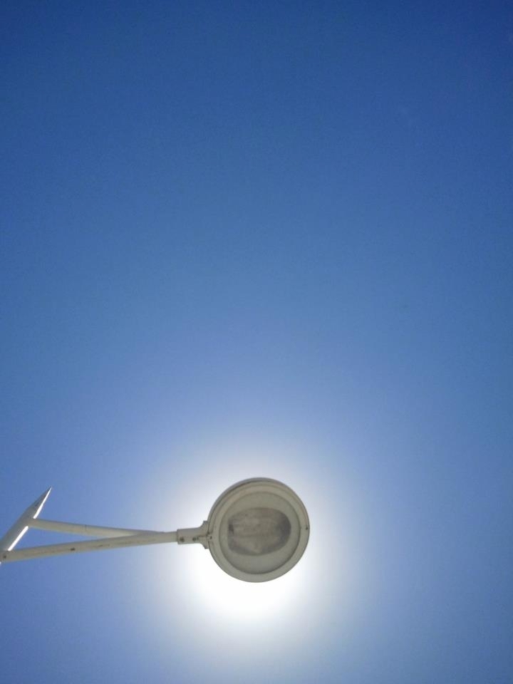 This photo I took when I was lying down in Balneário Camboriu´s harbor in Brazil. I realized it was a very interesting scene, a lamppost doing the exact opposit work, protecting me from the strong though natural light of the sun.