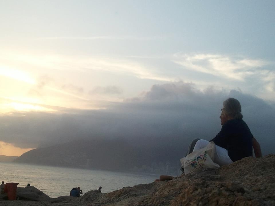 An elderly couple enjoying the magical sunset of the beautiful Arpoador, next to Ipanema´s beach in Rio de Janeiro, Brasil.