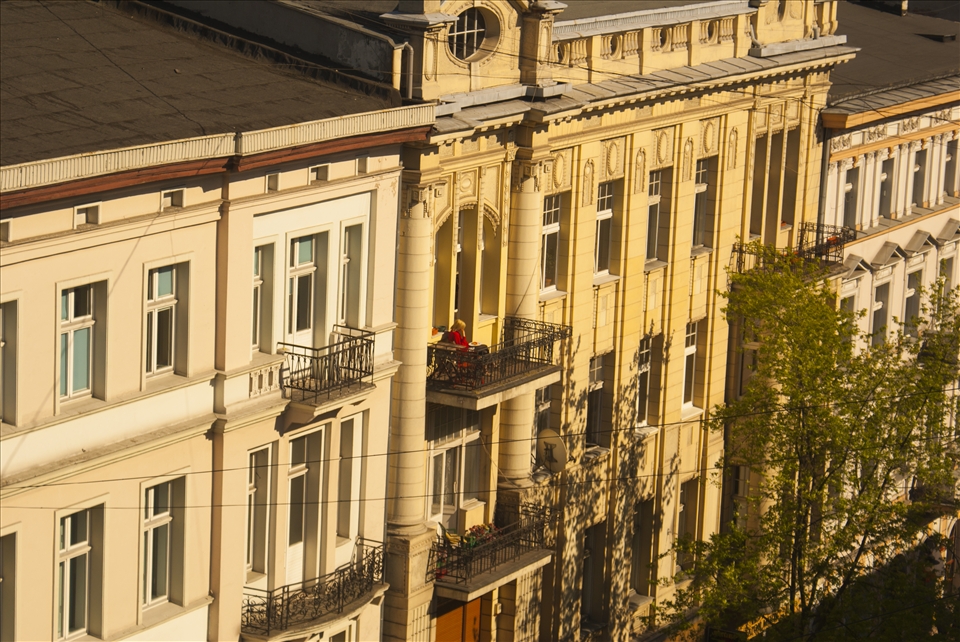 A woman reads a book in the afternoon light in Piotrkowska street