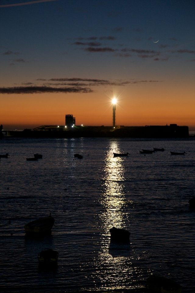 The crescent moon looming over the harbor in Cadiz.