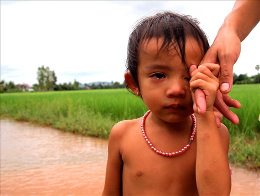 'a girl and her pearls' - taken in the rural town of Kampot in South Cambodia. It was in the middle of the rainy season and I was cycling through a flooded dirt road. I passed this little girl and her mother, she was completely naked apart from the string of pearls around her neck. gorgeous.