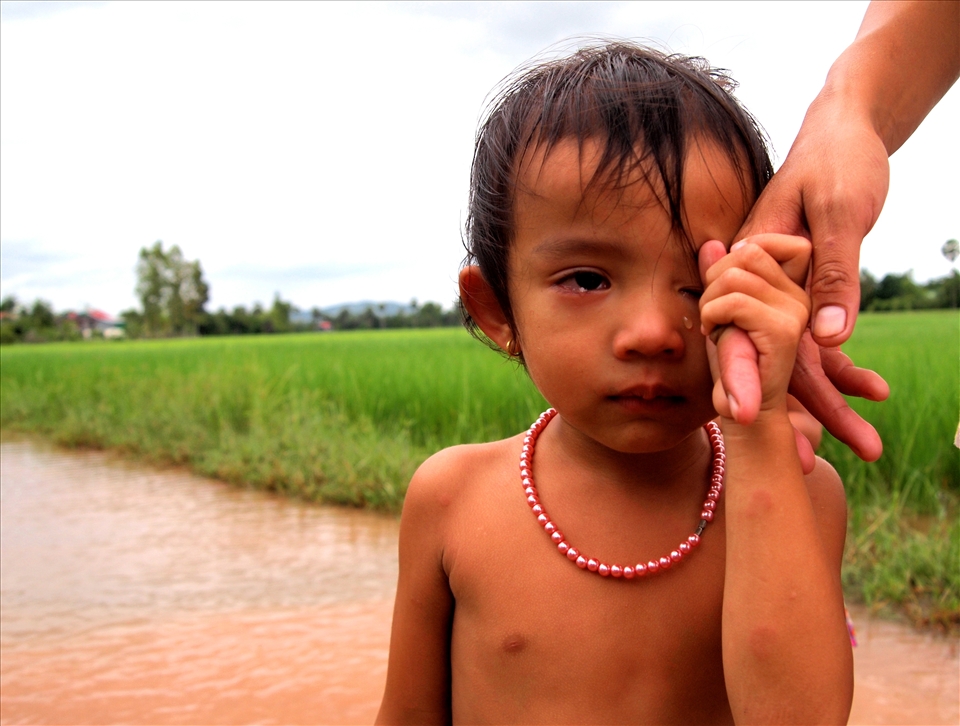 'a girl and her pearls' - taken in the rural town of Kampot in South Cambodia. It was in the middle of the rainy season and I was cycling through a flooded dirt road. I passed this little girl and her mother, she was completely naked apart from the string of pearls around her neck. gorgeous.