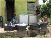 Two women washing clothes by hand next to previously donated  washing machines. The scene seemed odd, and I wondered why they were not using the appliances. I later learned they simply could not, as the machines were not adapted to their living conditions. : by onethousandwords, Views[716]