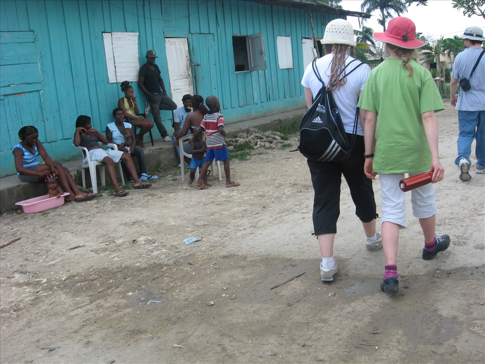 Group of tourists passing by inhabitants of the batey. 
The inhabitants of the host country were gathered outside sharing a moment together. I remember feeling like an unwanted guest, a creature part of a herd of loud animals with hoofs so big they could destroy everything they stepped on, a group of unjustly privileged human species confronted to a similar reality they face back home: homelessness. This moment seemed to summarize all I had ever learned on inequality, except this time it had a face.  